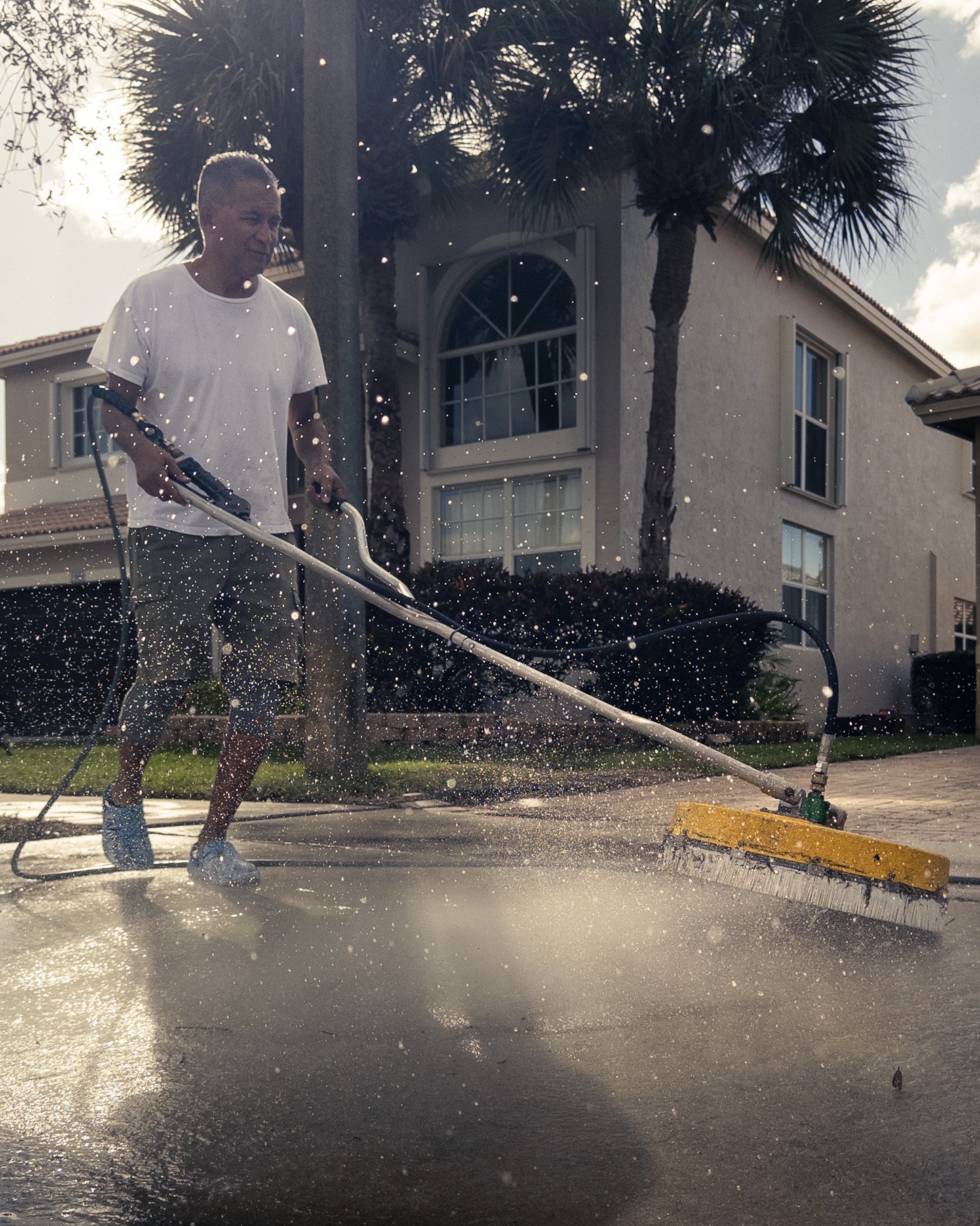 Excellence Pressure Cleaning technician power washing a driveway in South Florida